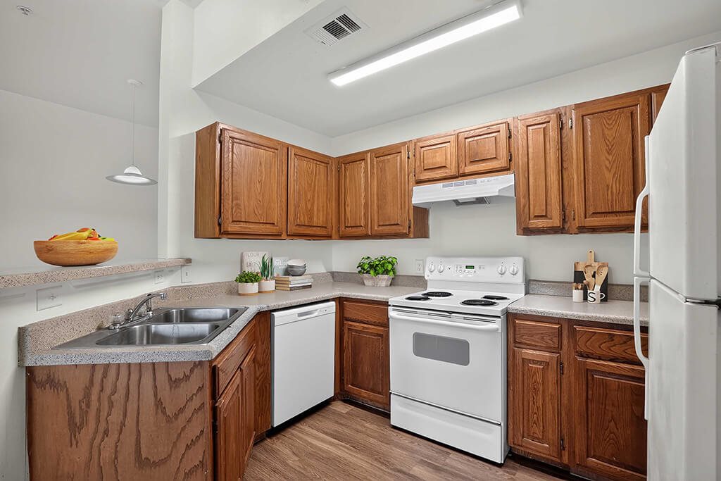 A kitchen with wooden cabinets and white appliances.